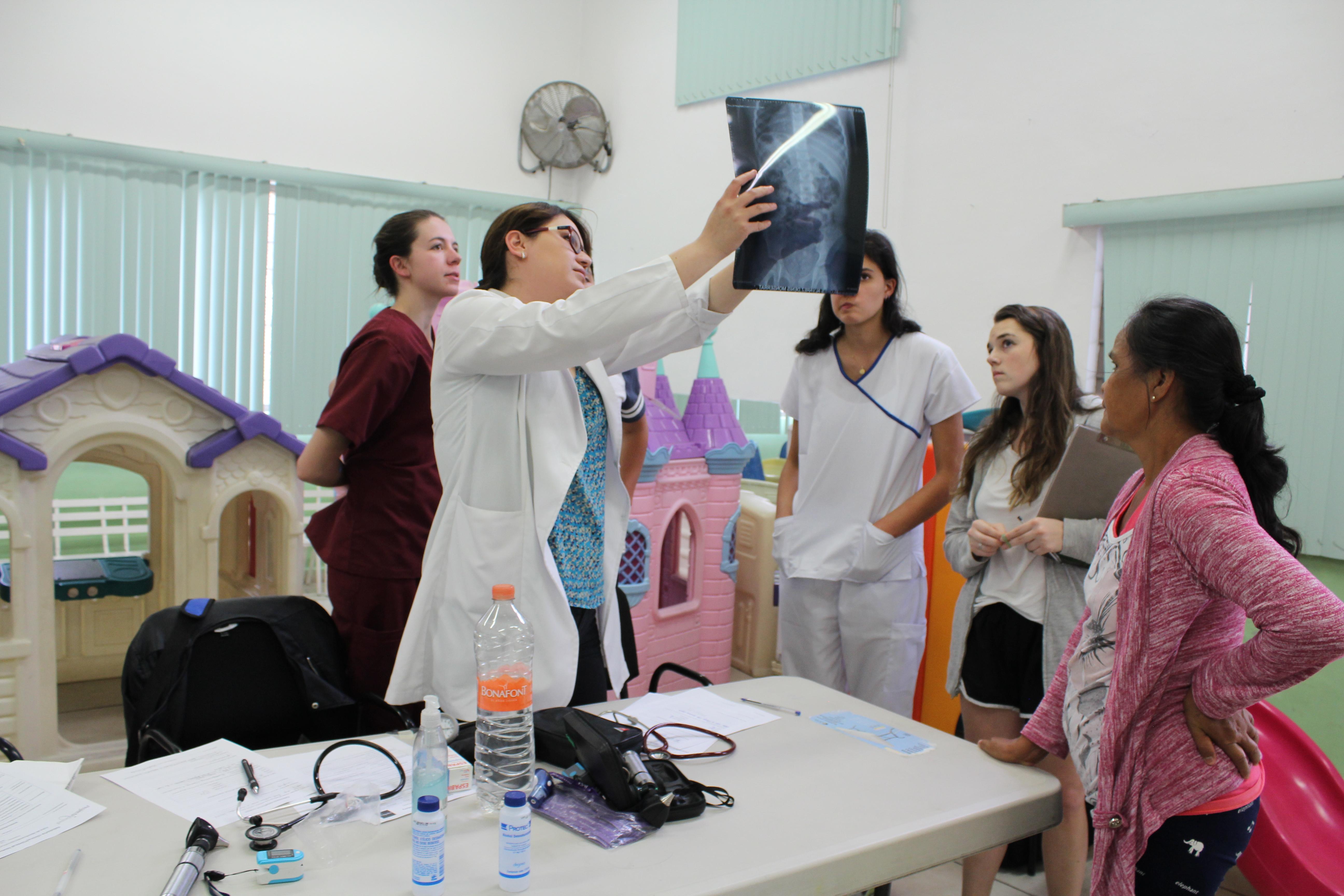 Projects Abroad Medicine interns examine an X-Ray that a local doctor is holding during their Medical Internship in Mexico. Medical interns on their Medicine internships in Mexico examine an X-Ray with a local doctor explaining what they see.